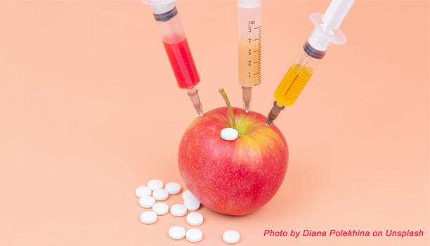 apple with hypodermic needles and pills