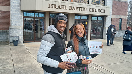 Young couple in front of Israel Baptist Church with their copyof 'Immunize Now!'