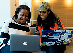 Two African-American women looking at laptops